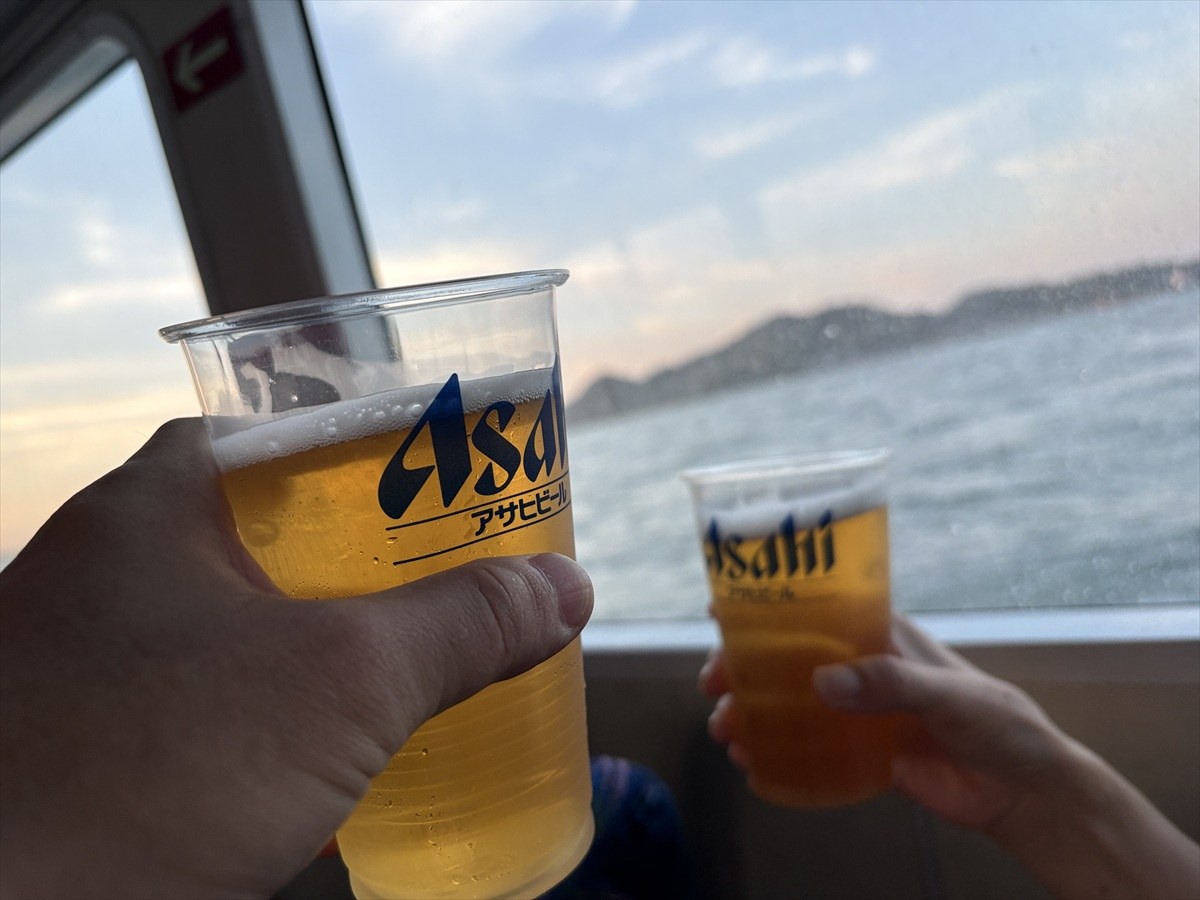 海を背にアサヒビールのプラカップで乾杯