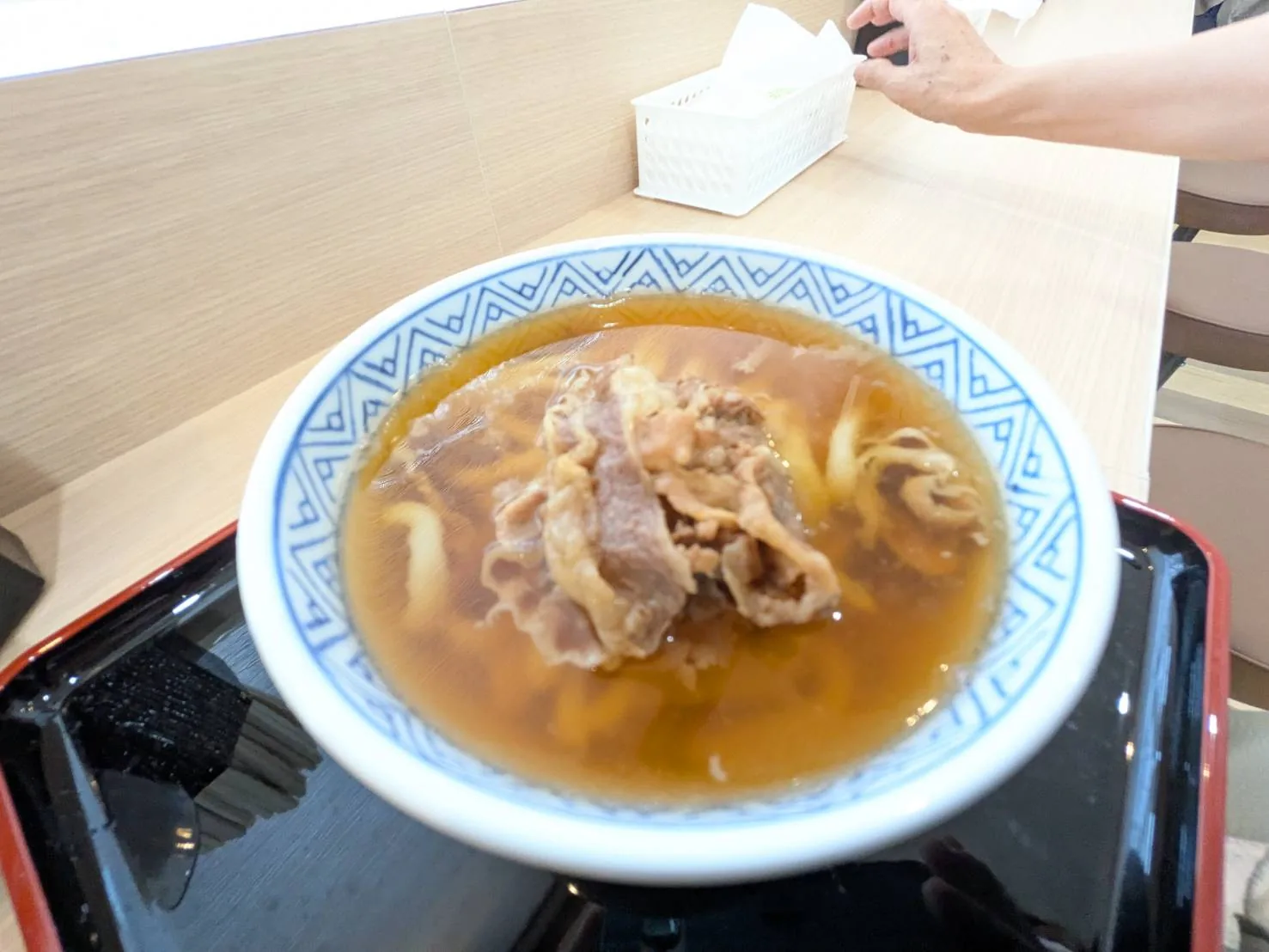 肉うどん。澄んだ琥珀色の出汁に牛肉がのる