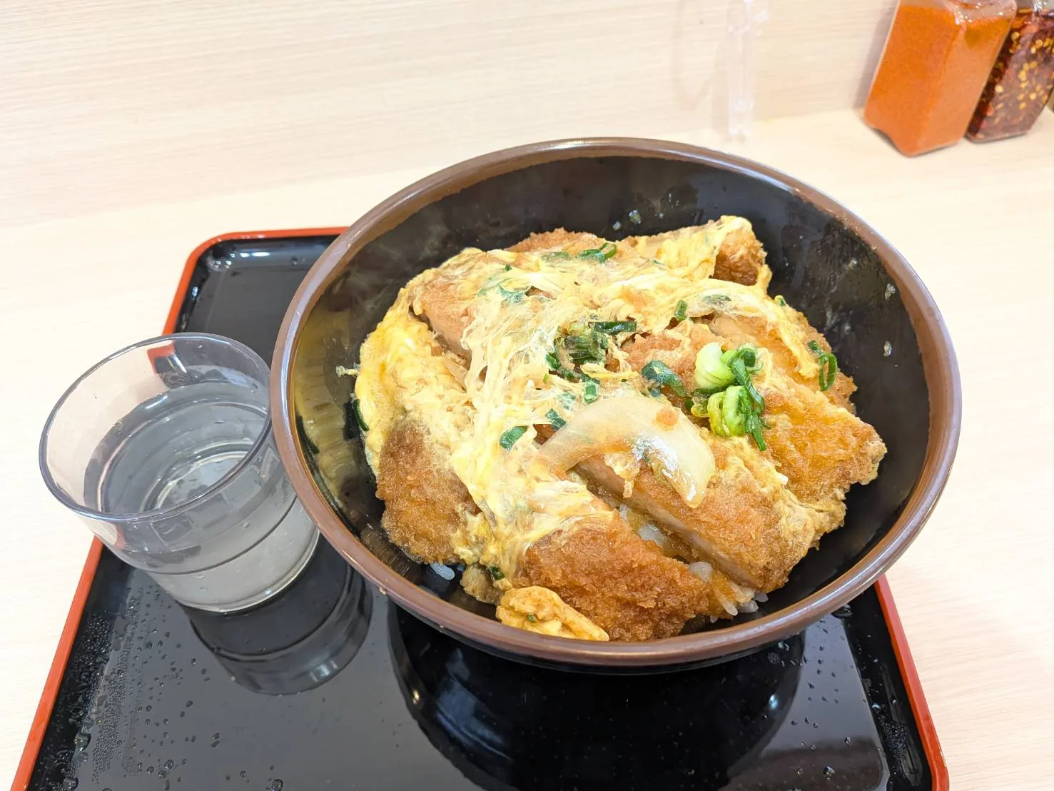 Wかつ丼大盛りとコップ。丼のサイズが分かる