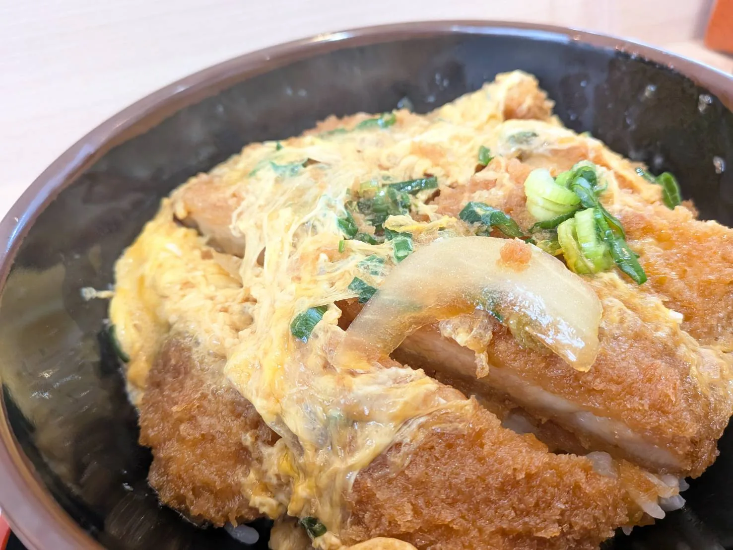 Wかつ丼のアップ。卵とじに玉ねぎと青ねぎがからむ