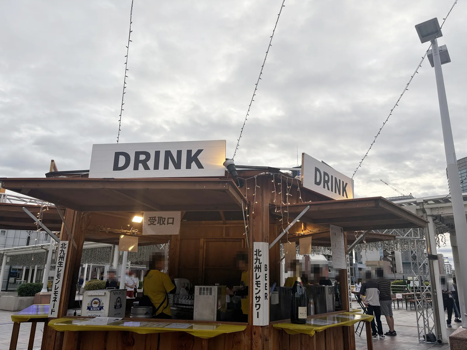 DRINKの看板を掲げた木製のドリンクコーナー。北九州生レモンレモネードと北九州レモンサワーの札
