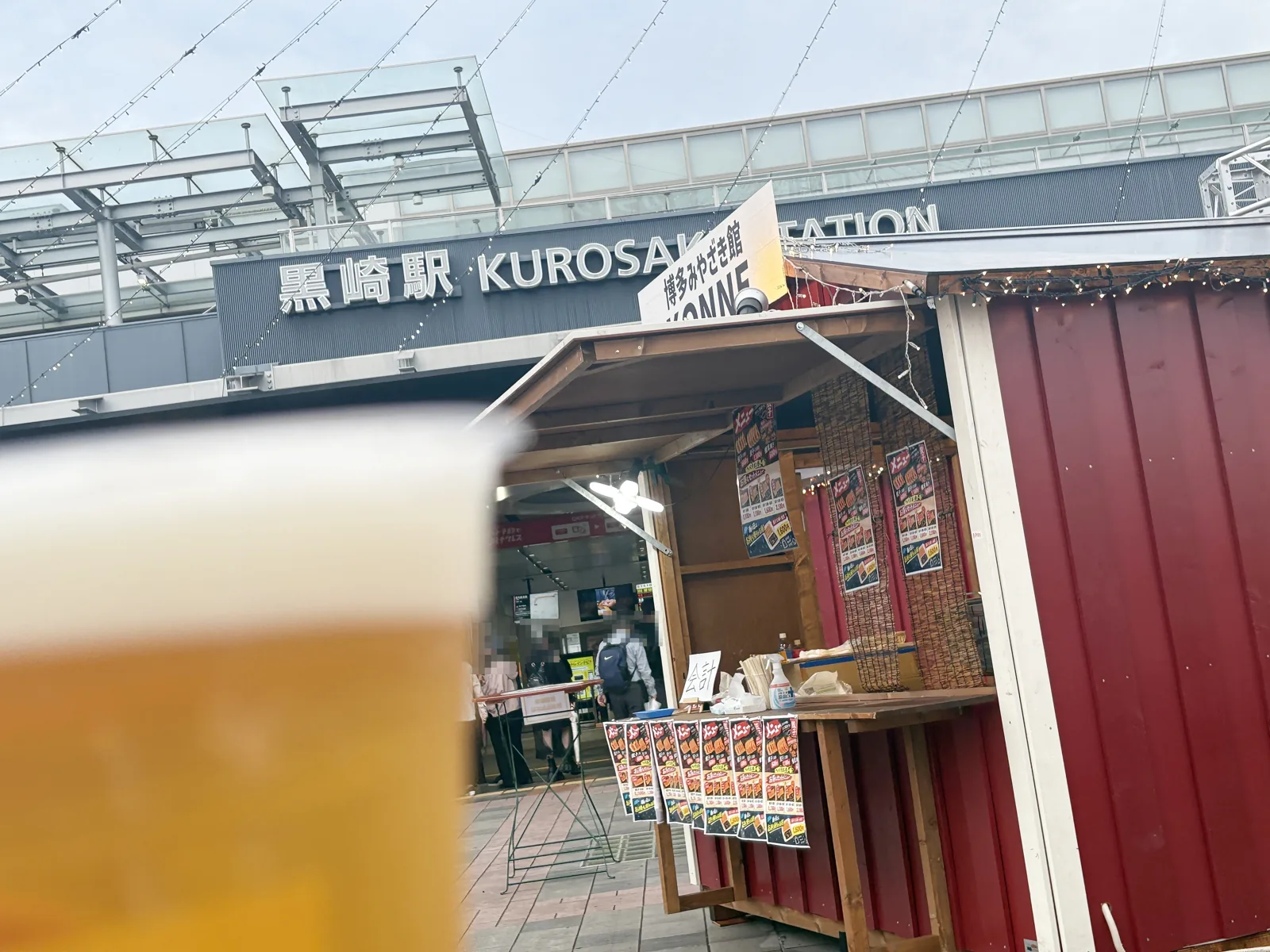 黒崎駅の駅名看板を借景に、手前に生ビールのカップ