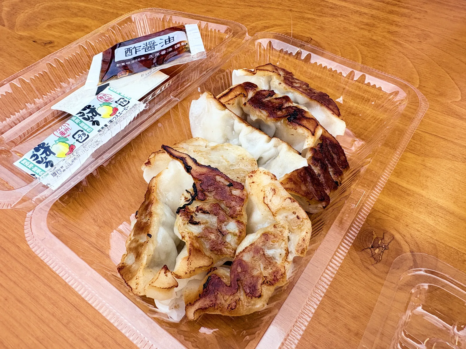 パックに入った八幡ぎょうざの焼餃子。酢醤油の小袋つき