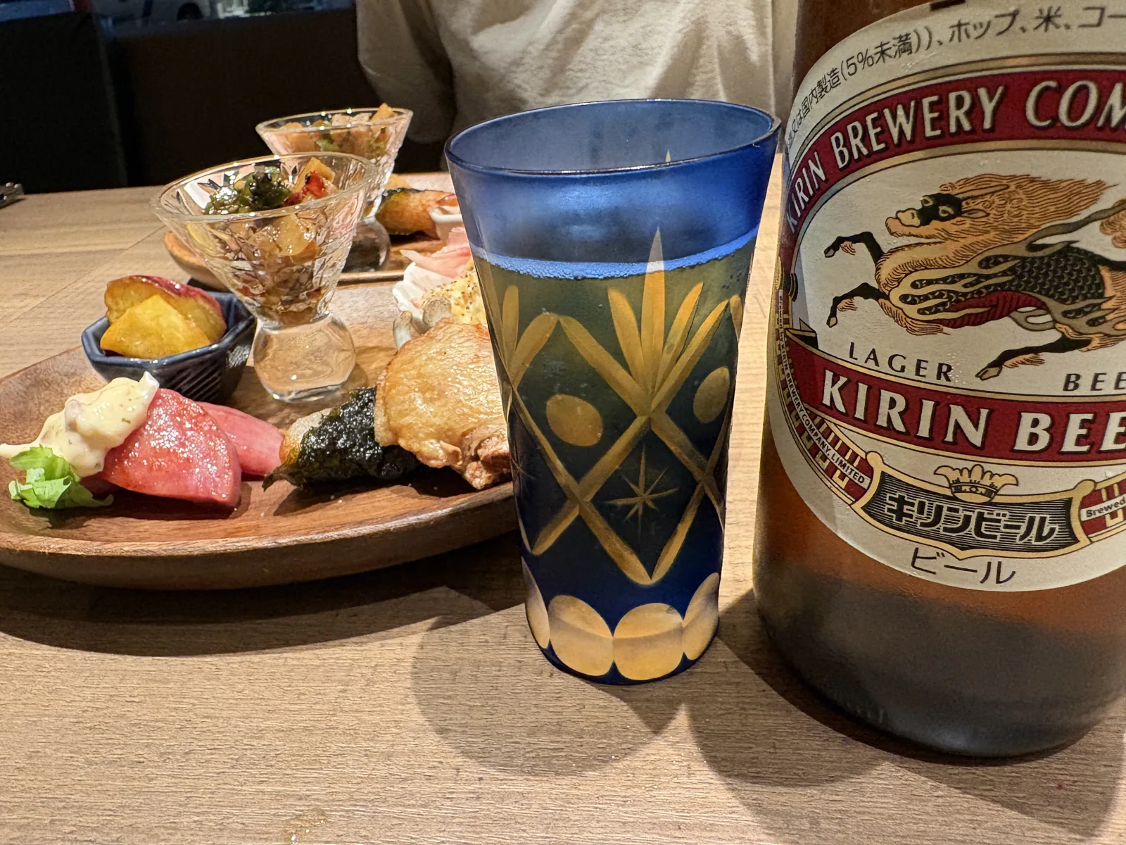 キリンの瓶ビールと、金の模様が入った青い切子グラス