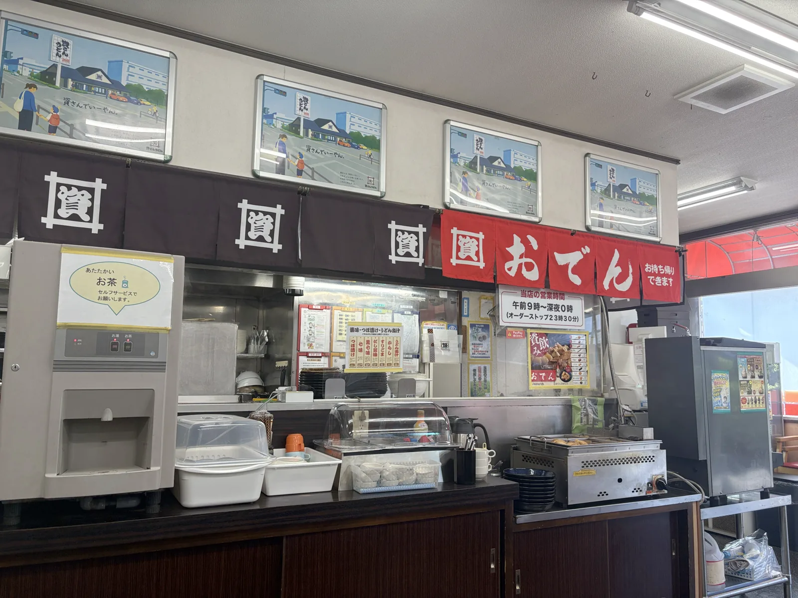 給茶機の横に並ぶ薬味コーナー。上に「薬味・つぼ漬け・うどん出汁」の札、右におでんの鍋
