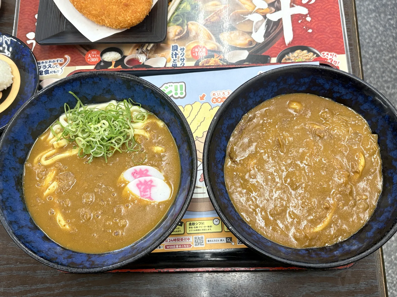 左に出汁カレーうどん、右にカレーぶっかけうどん。奥に別皿のコロッケ