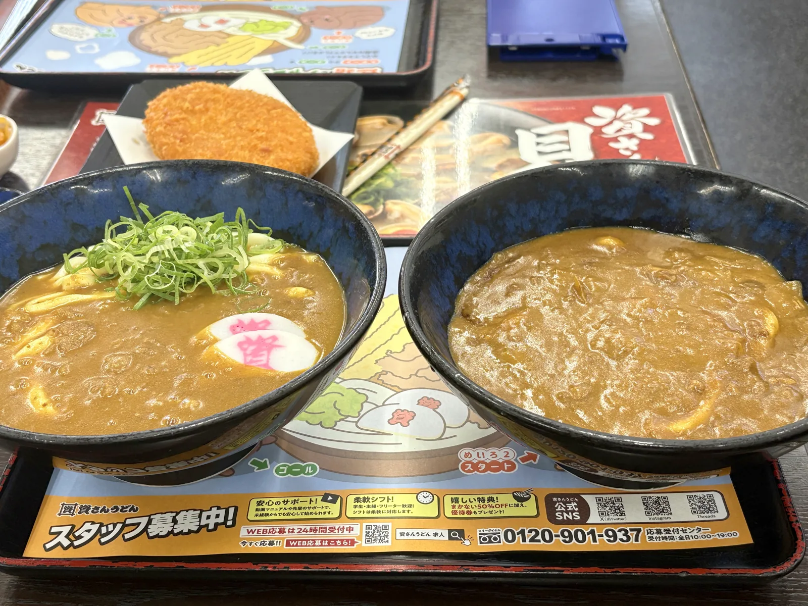 2つのカレーうどんを斜めから。左の出汁カレーはスープ状、右のぶっかけはとろみが強い