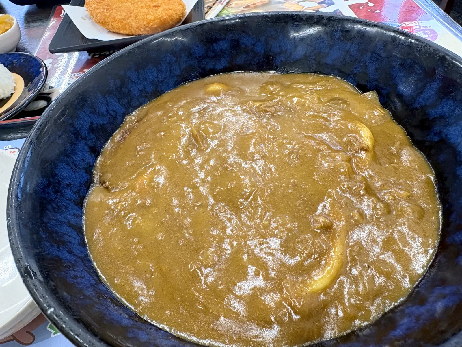 カレーぶっかけうどんのアップ。とろみのあるカレーが麺を覆っている