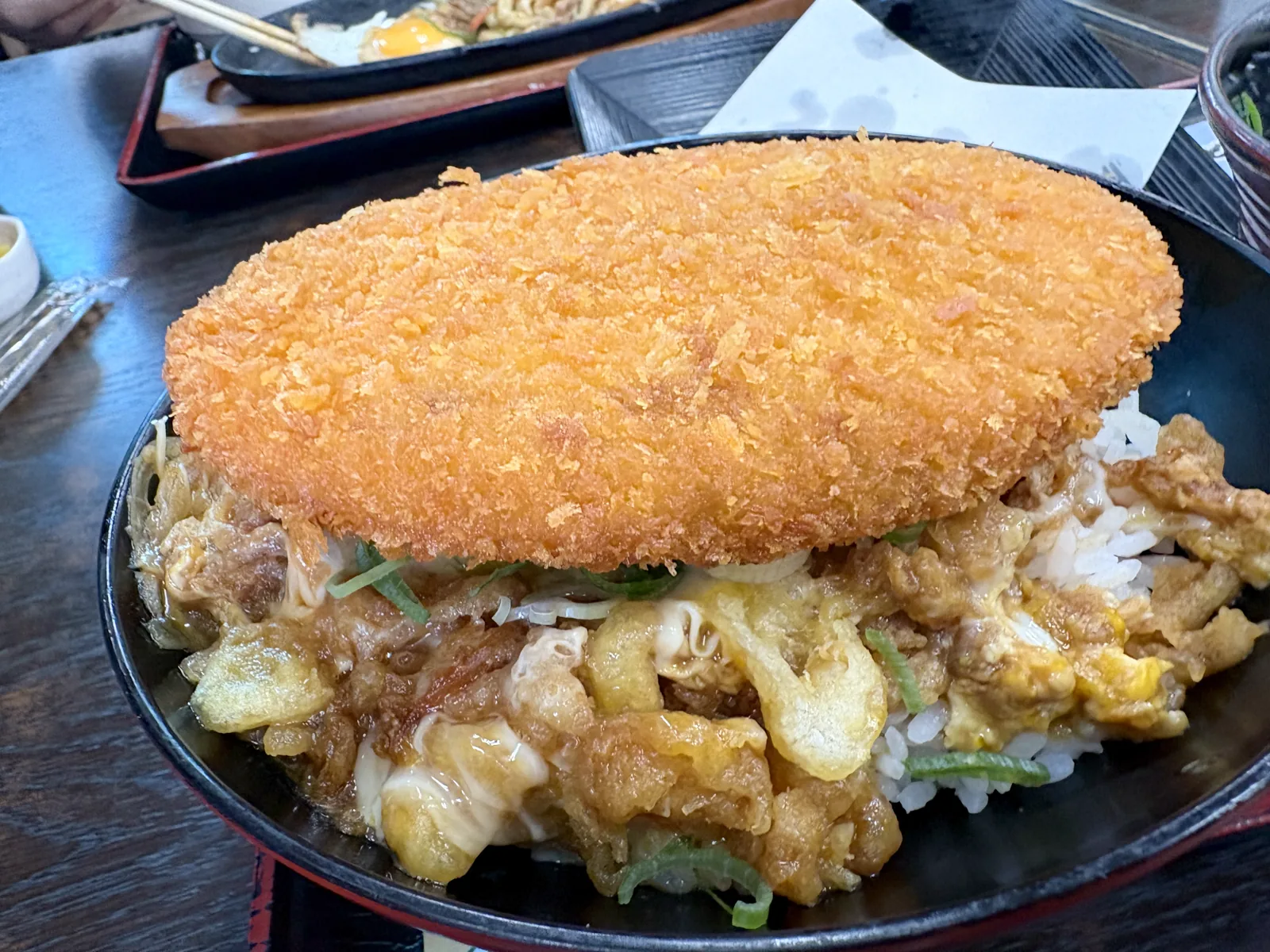 コロッケ丼を斜めから。奥に焼きうどんの鉄板