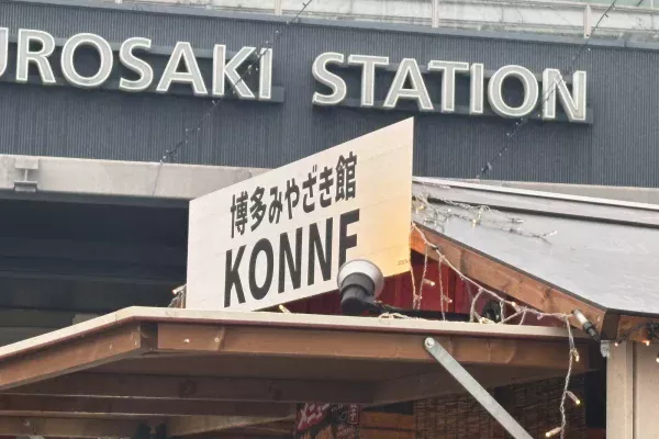 JR黒崎駅の駅名看板を背に立つ「博多みやざき館KONNE」の屋台