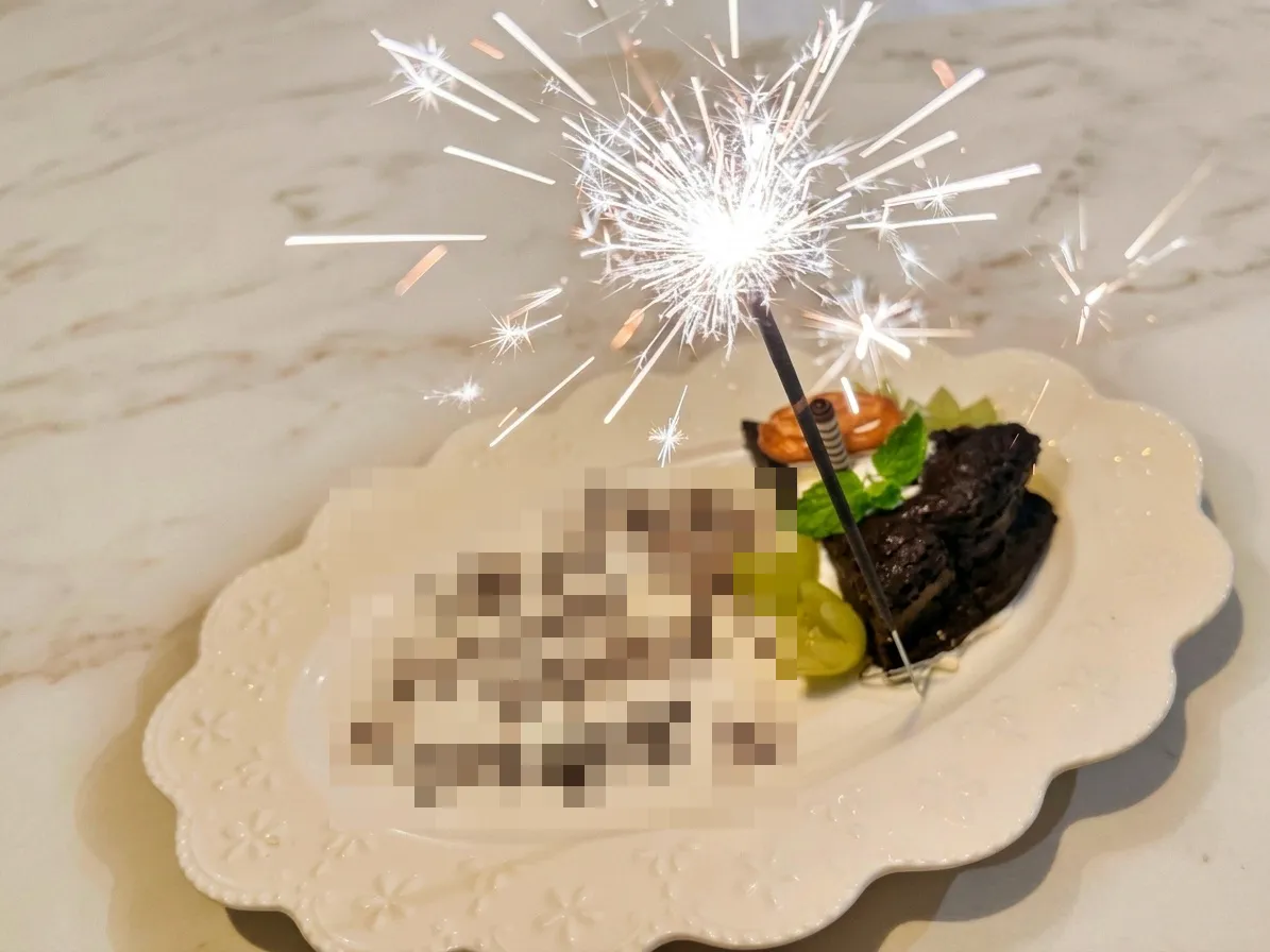 花火がパチパチと光るバースデープレート。チョコレートのケーキと、チョコペンのメッセージ（名前と年齢はモザイク）