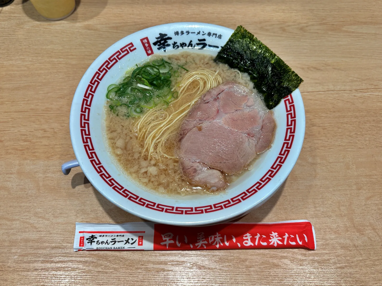 背脂豚骨ラーメン。白地に赤い雷紋の丼に、大判チャーシュー、ねぎ、のり