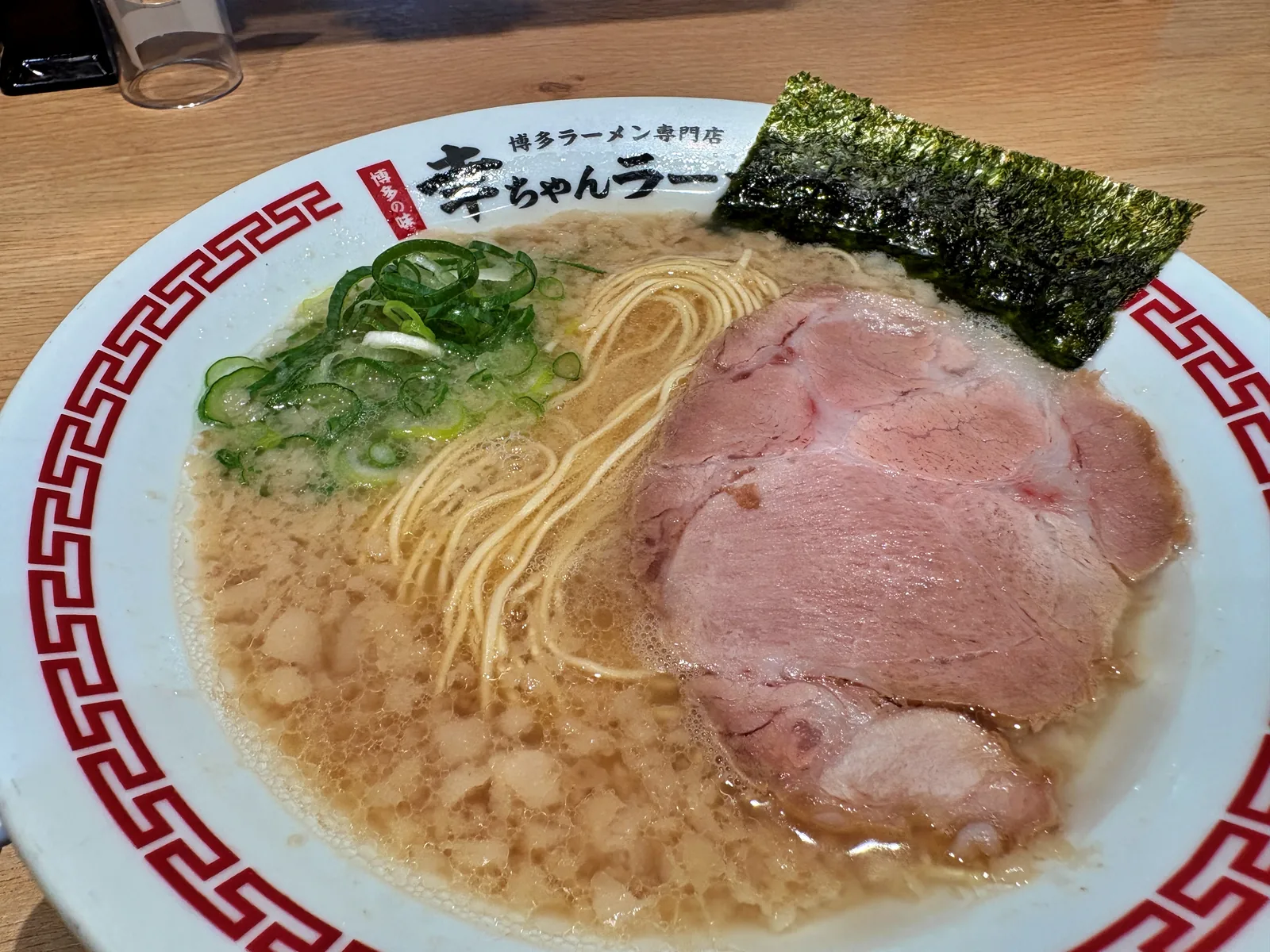 背脂豚骨ラーメンのアップ。スープの表面一面に背脂の粒が浮いている