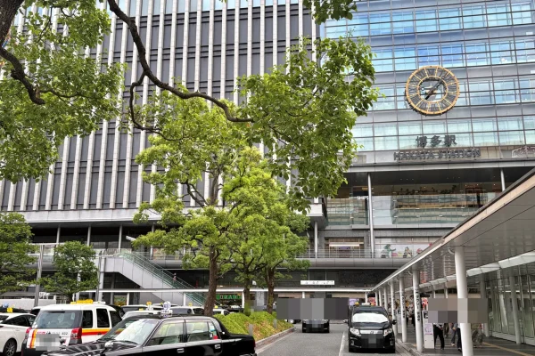 博多駅の駅舎。大時計と「博多駅 HAKATA STATION」の文字、手前にタクシー乗り場と街路樹