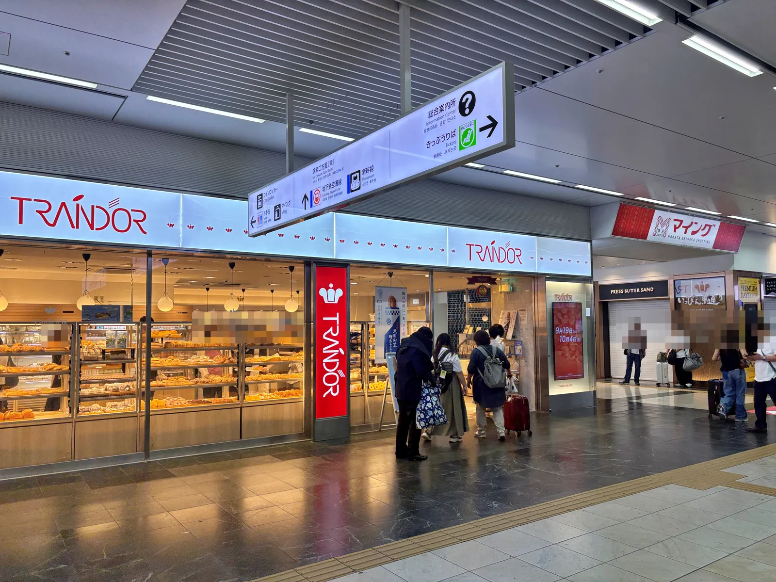 トランドール博多駅店。ショーケースにパンが並び、早朝から客が入っている