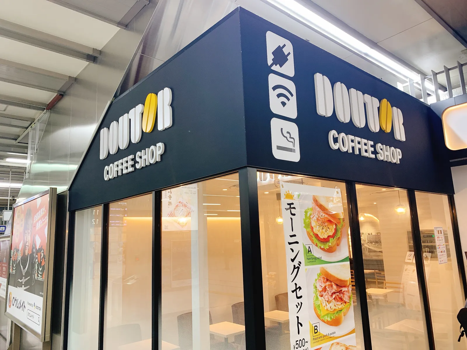 ドトールの外観。電源・Wi-Fi・喫煙のマーク。モーニングセットA ハムタマゴサラダ、B パストラミポーク&ポテト ¥500〜