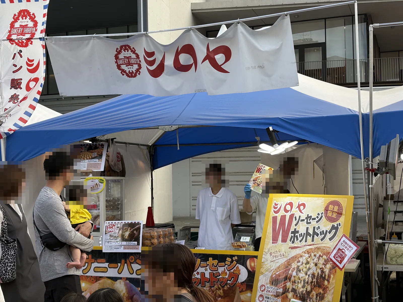 シロヤの出店テント。「シロヤ」の幕とWソーセージホットドッグの看板