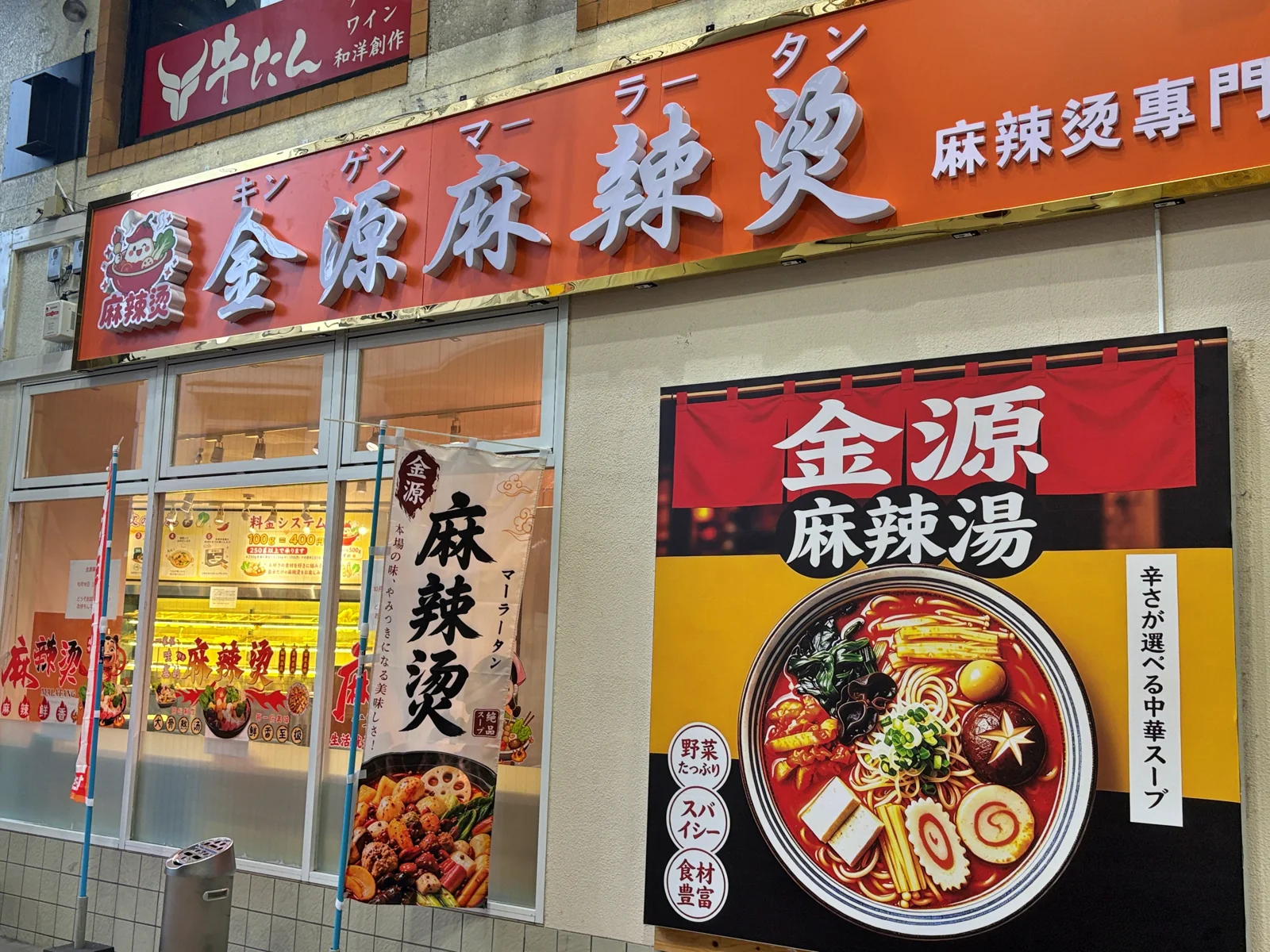 金源麻辣湯の看板と、「辛さが選べる中華スープ」と書かれた麻辣湯のポスター、「麻辣燙」ののぼり