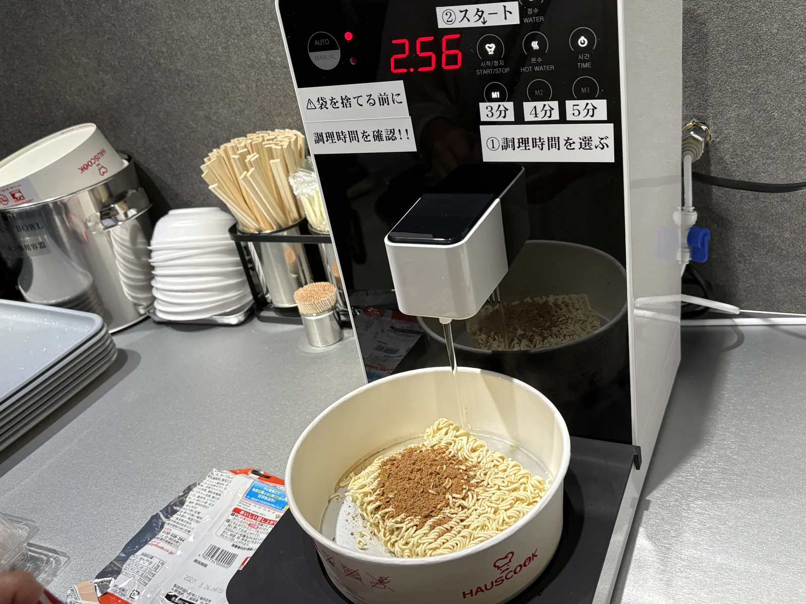 自動調理器に容器をセット。表示は2:56のカウントダウン。上から湯が注がれている