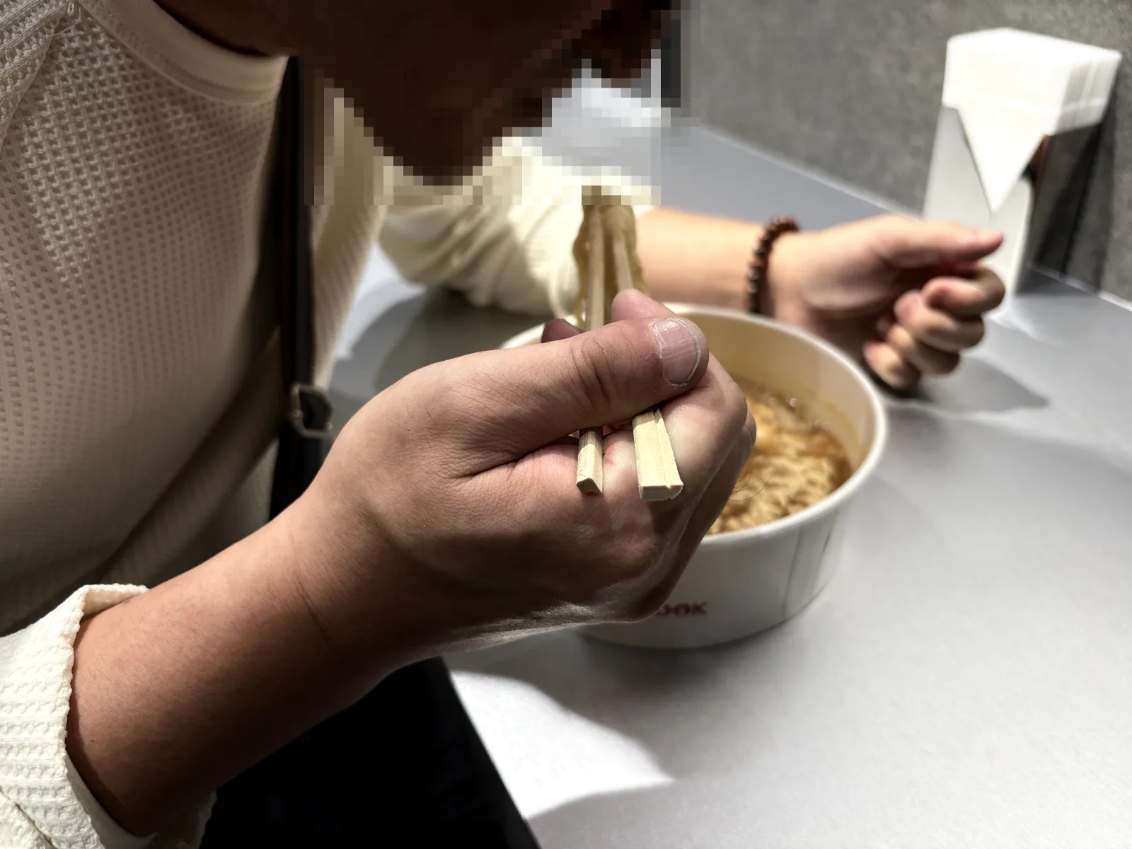 カウンターでラーメンをすする