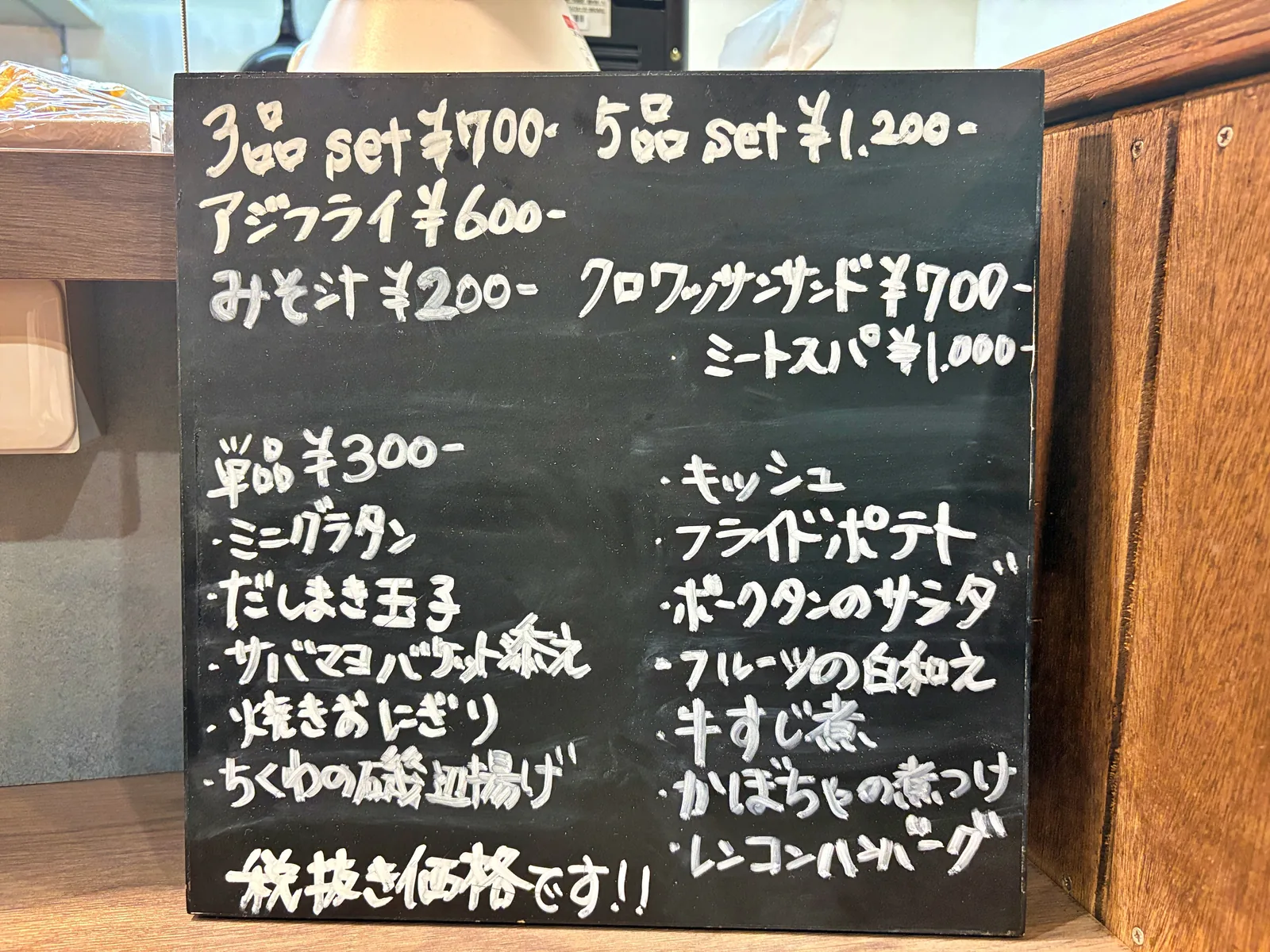 黒板メニュー。3品set700円、5品set1,200円、アジフライ600円、単品300円のおばんざいが並ぶ