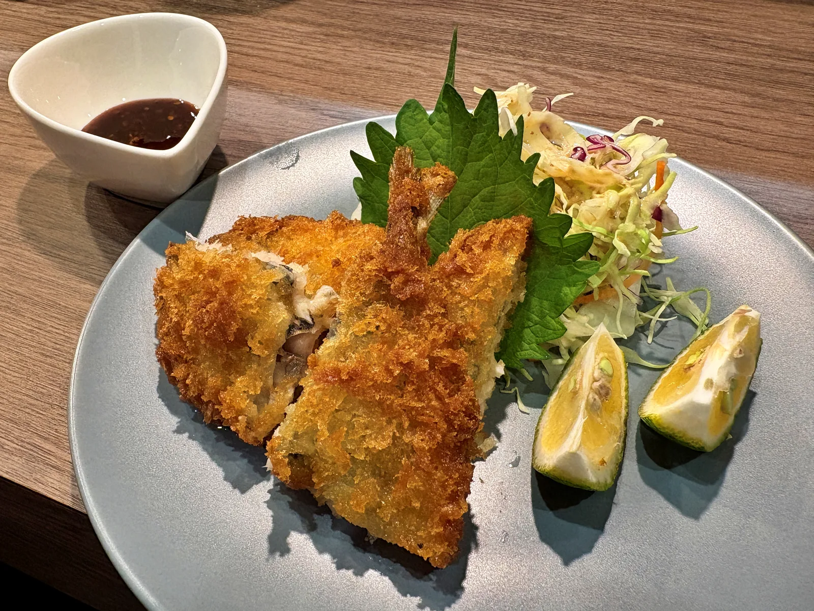 大葉とキャベツを添えたアジフライ2枚。柑橘2切れとソースの小鉢付き
