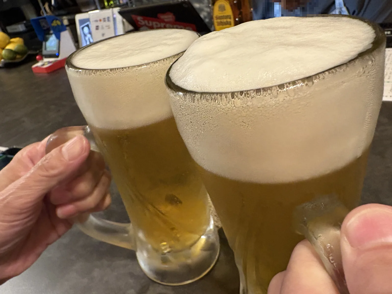 キンキンに冷えたジョッキの生ビール2杯で乾杯。泡がジョッキの縁からこんもり盛り上がっている
