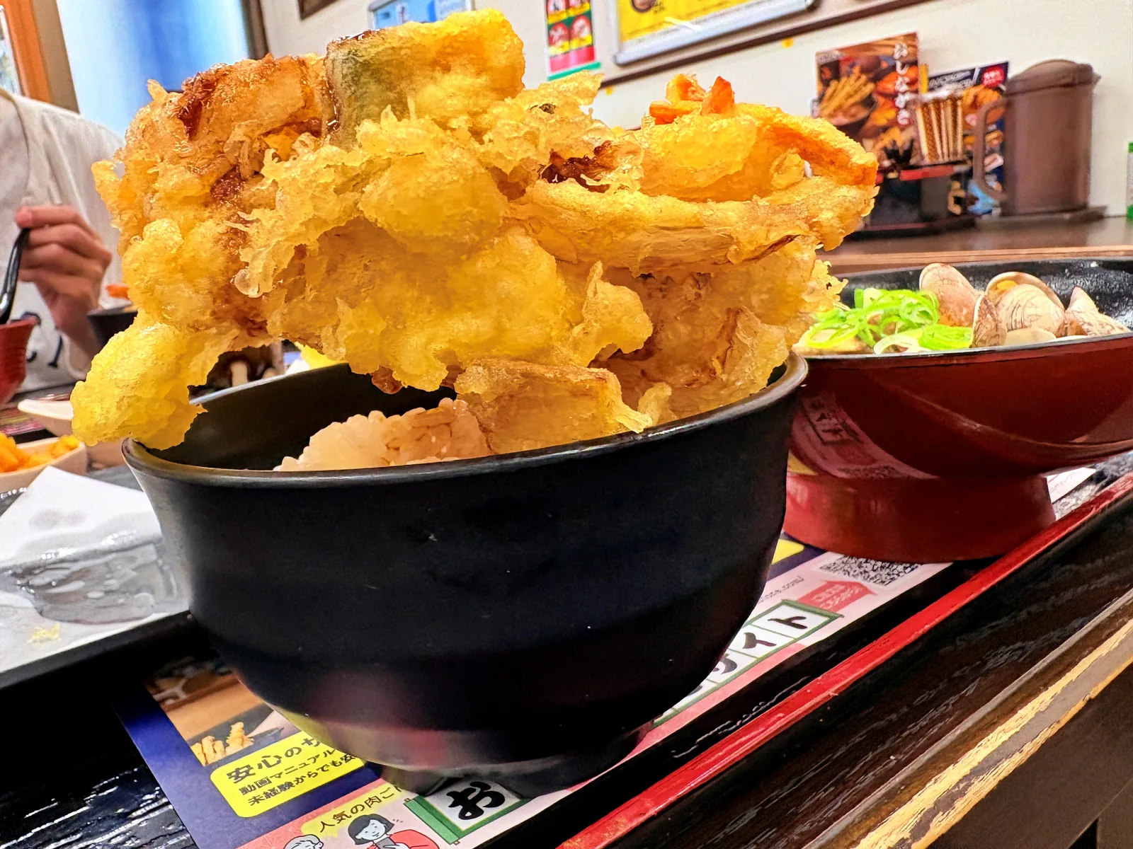 ローアングルで見たかき揚げオンザライス。茶碗の上にかき揚げが山のように盛り上がる