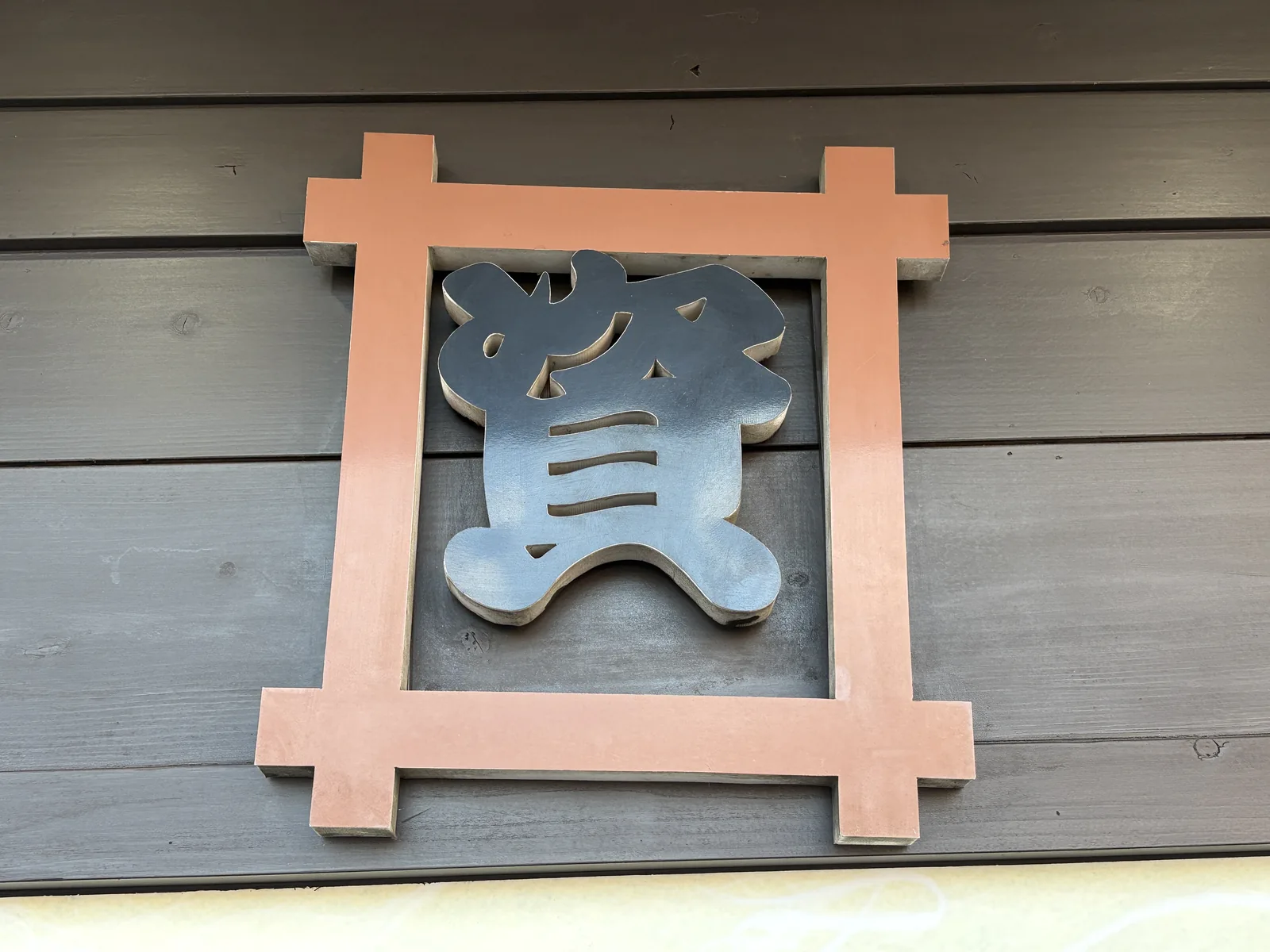 資さんうどん陣山店の「資」の看板。朱色の枠の右上がずれて曲がっている