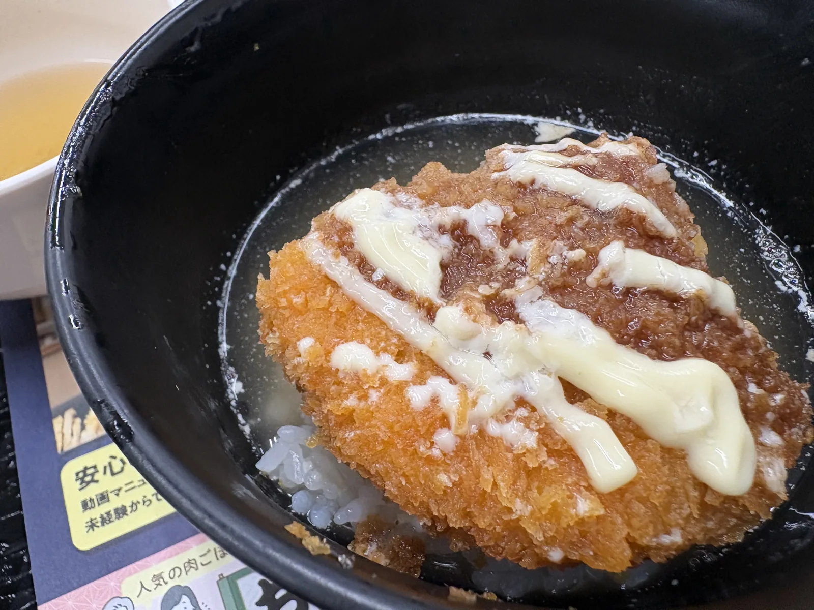 残したコロッケとごはんに出汁を注いだ「コロッケ茶漬け」。マヨネーズが出汁に溶けかけている