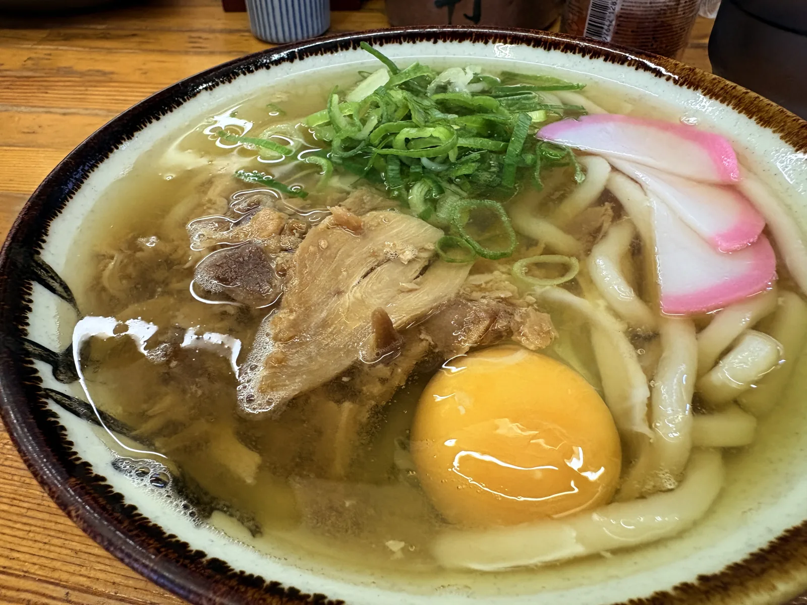 月見うどん。黄身がまんまるの生卵と、かしわ、かまぼこ