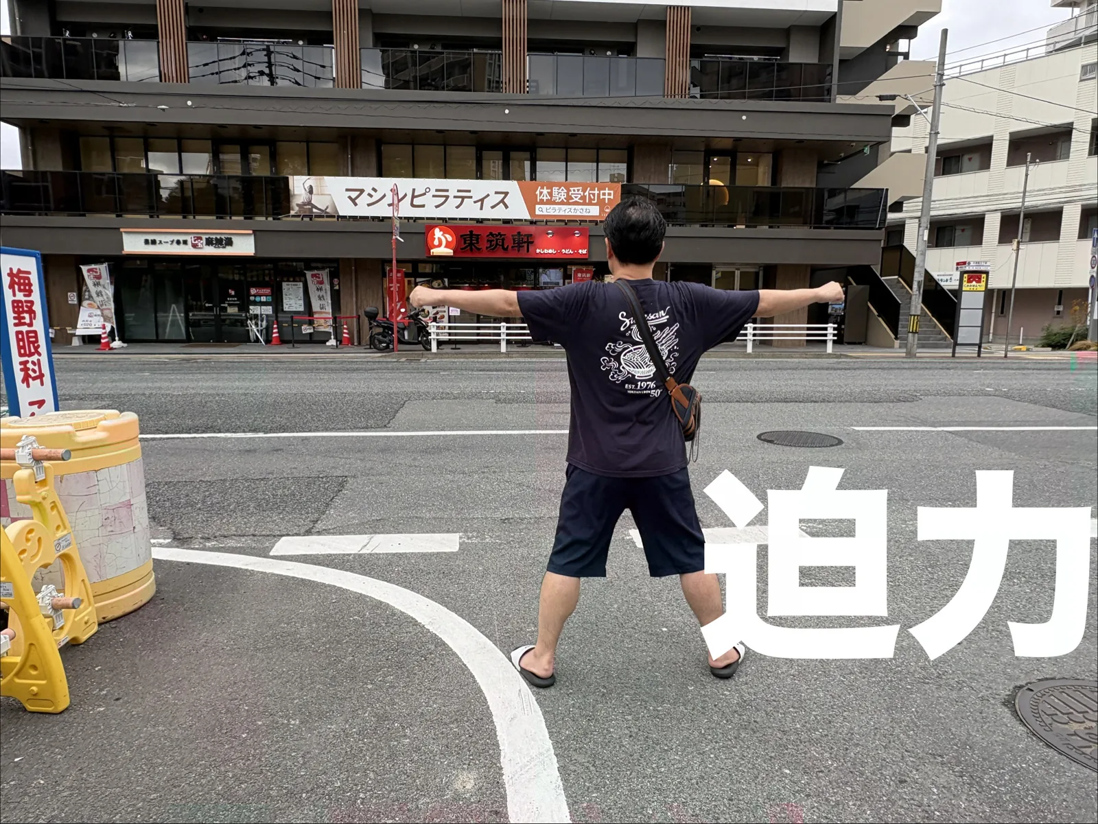 六本松店の前で迫力ポーズ。道路の向こうに赤い「東筑軒」の看板