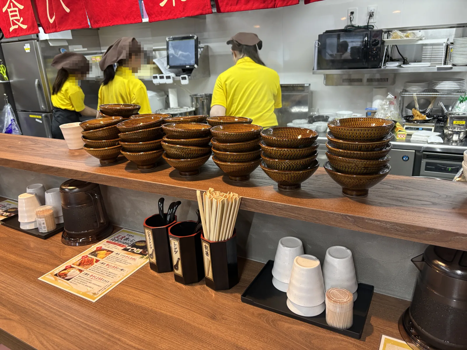 カウンターに小石原焼の茶碗がずらり。手前に穴あきレンゲ・レンゲ・割箸
