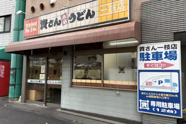 資さんうどん一枝店の外観。右に「資さん一枝店 駐車場 すぐヨコ!!」「専用駐車場（12台）」の看板