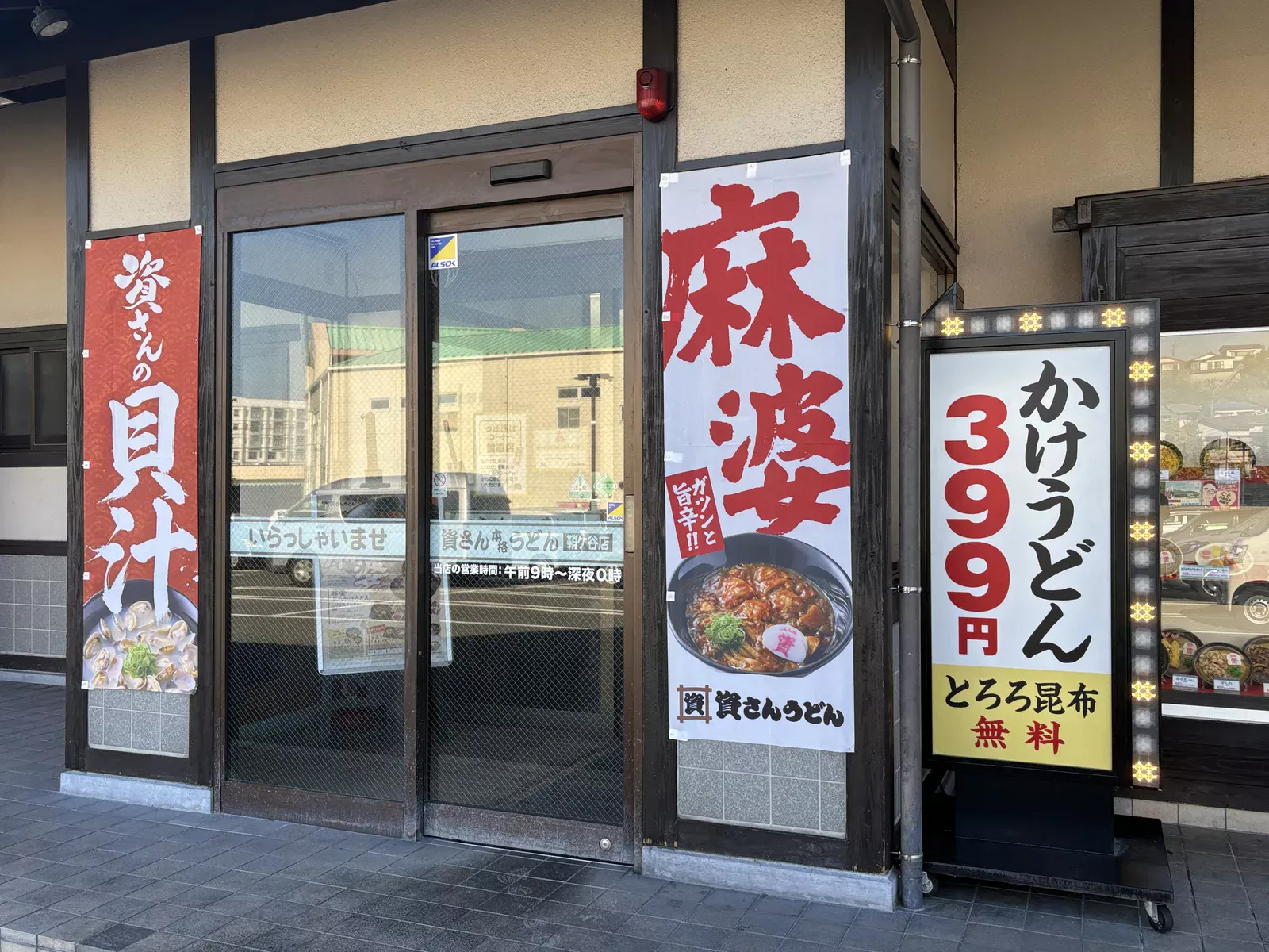 入口の横に、LEDで縁取られた電飾看板「かけうどん 399円 とろろ昆布無料」
