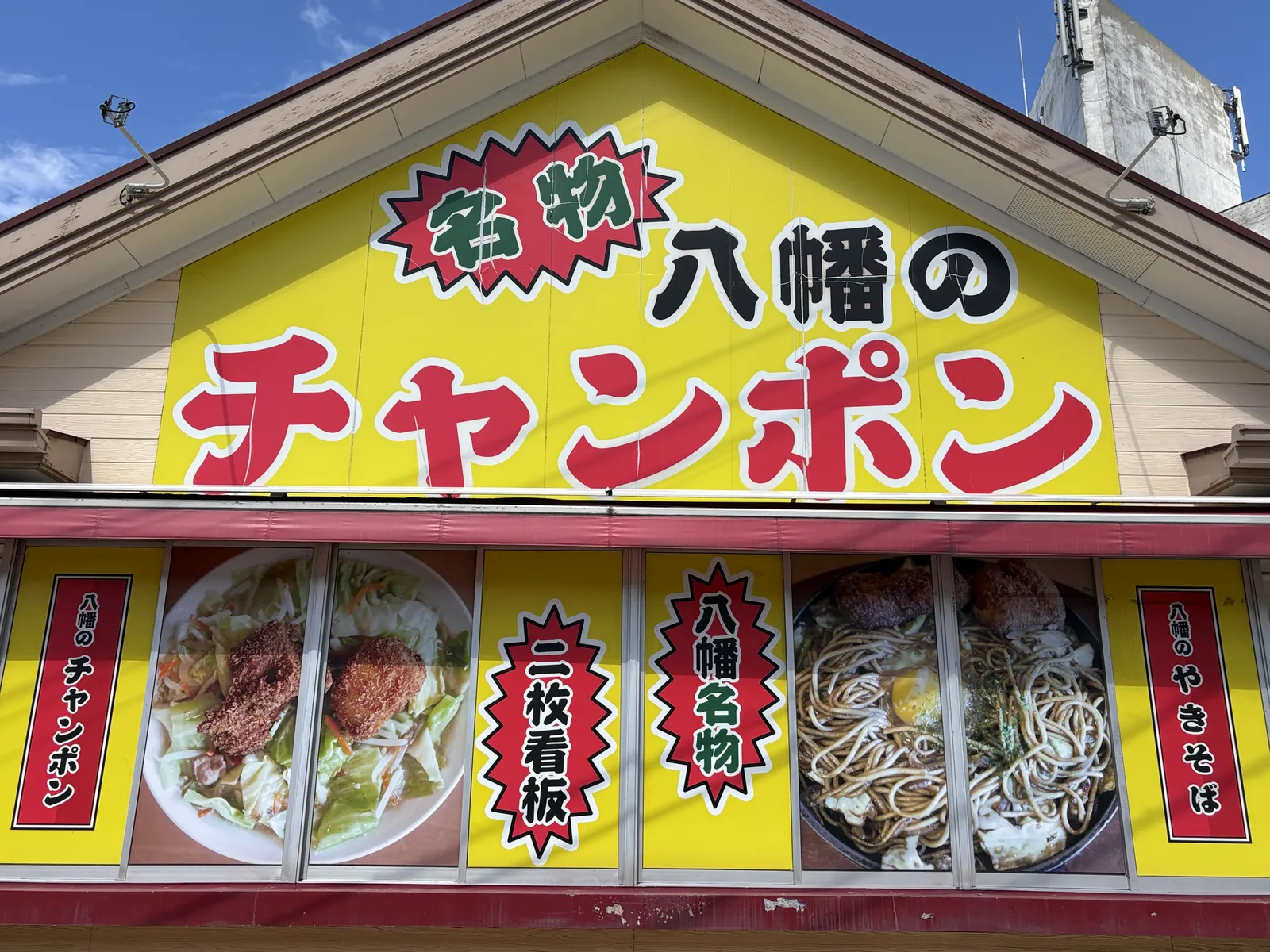 看板のアップ。窓にチャンポンと焼そばの写真、「二枚看板」「八幡名物」の文字
