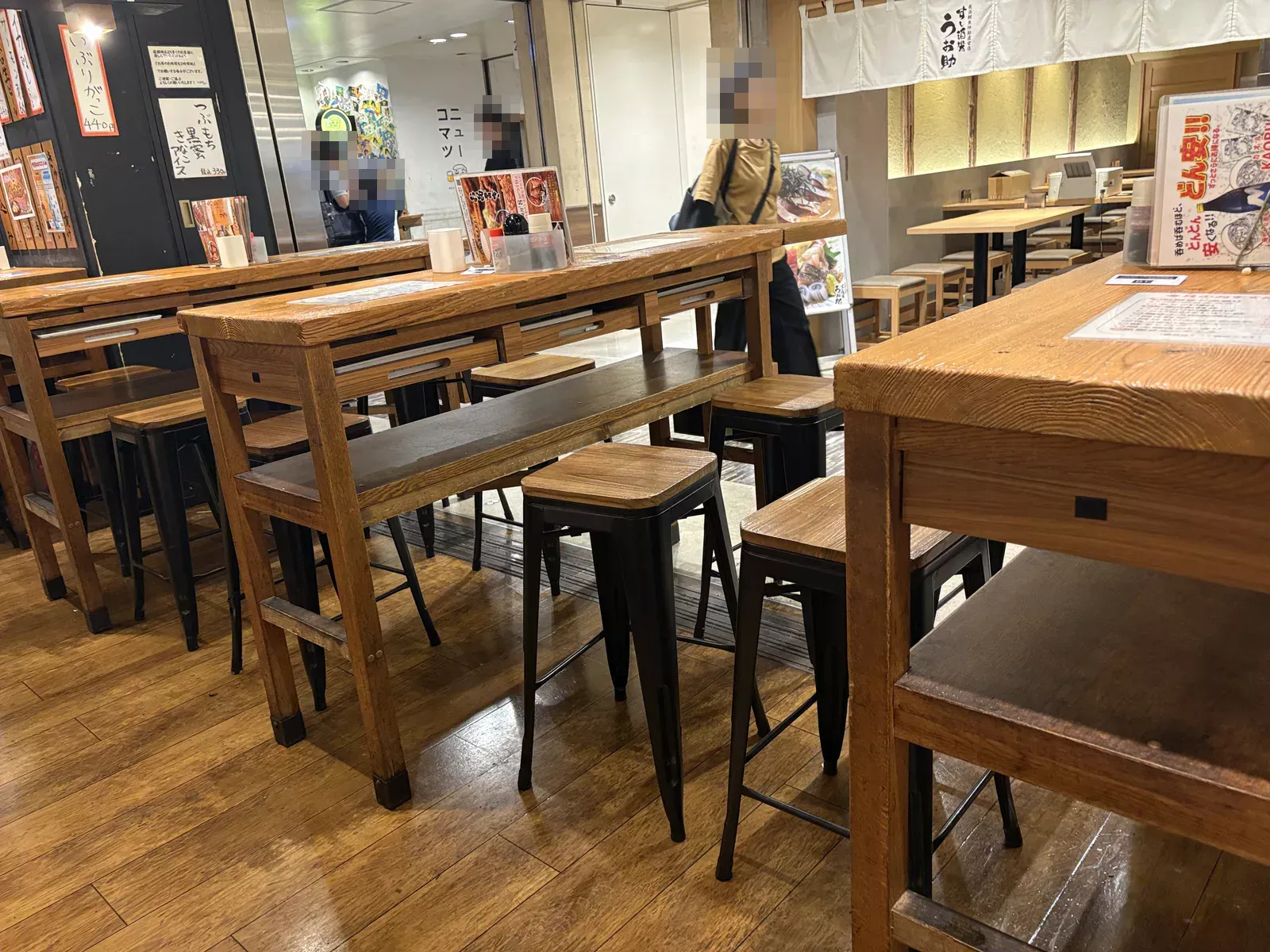 開店直後の店内。木のハイテーブルと背の高いスツールが並び、客はまだいない