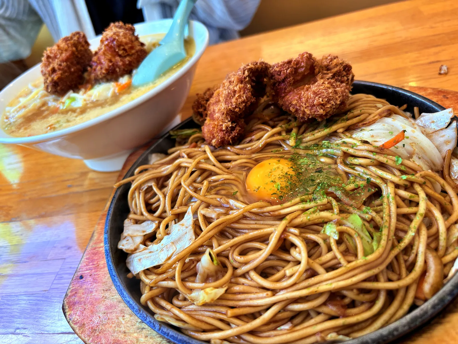 八幡の焼そば。鉄皿の真ん中に生卵の黄身、青のり、チキンカツ2個