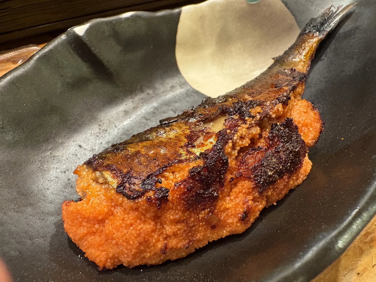 イワシ明太。焼いたイワシのお腹に明太子が詰まり、表面が香ばしく焦げている