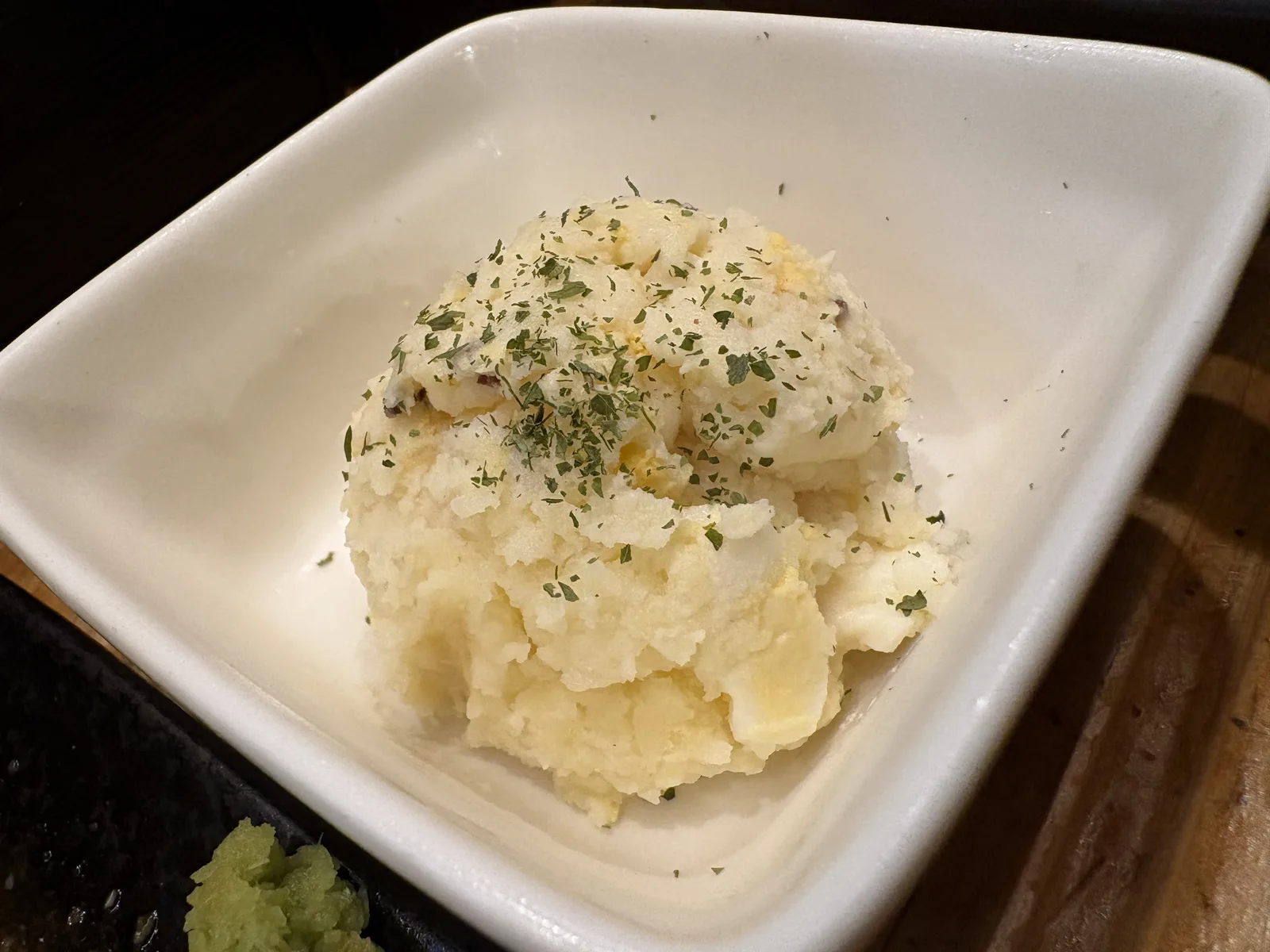 ポテトサラダ。白い器に丸く盛られ、パセリが散らされている