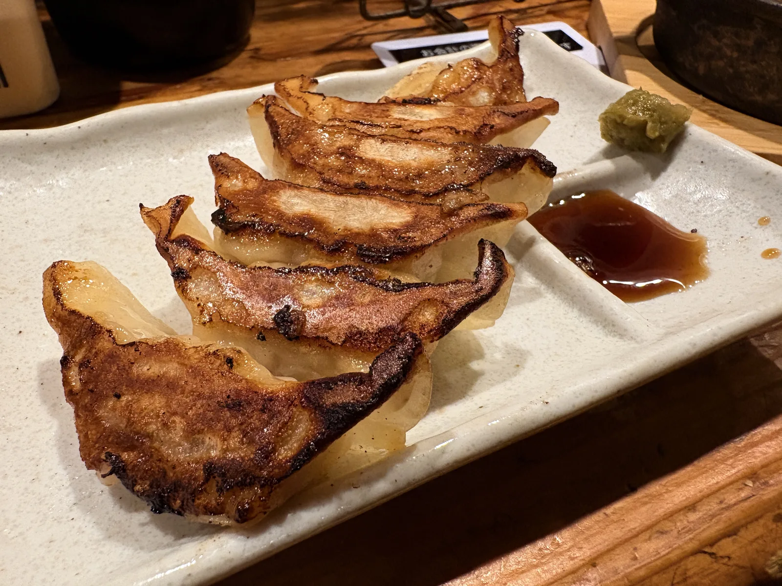 博多一口餃子6個。焼き目のついた餃子に、タレと柚子胡椒が添えられている