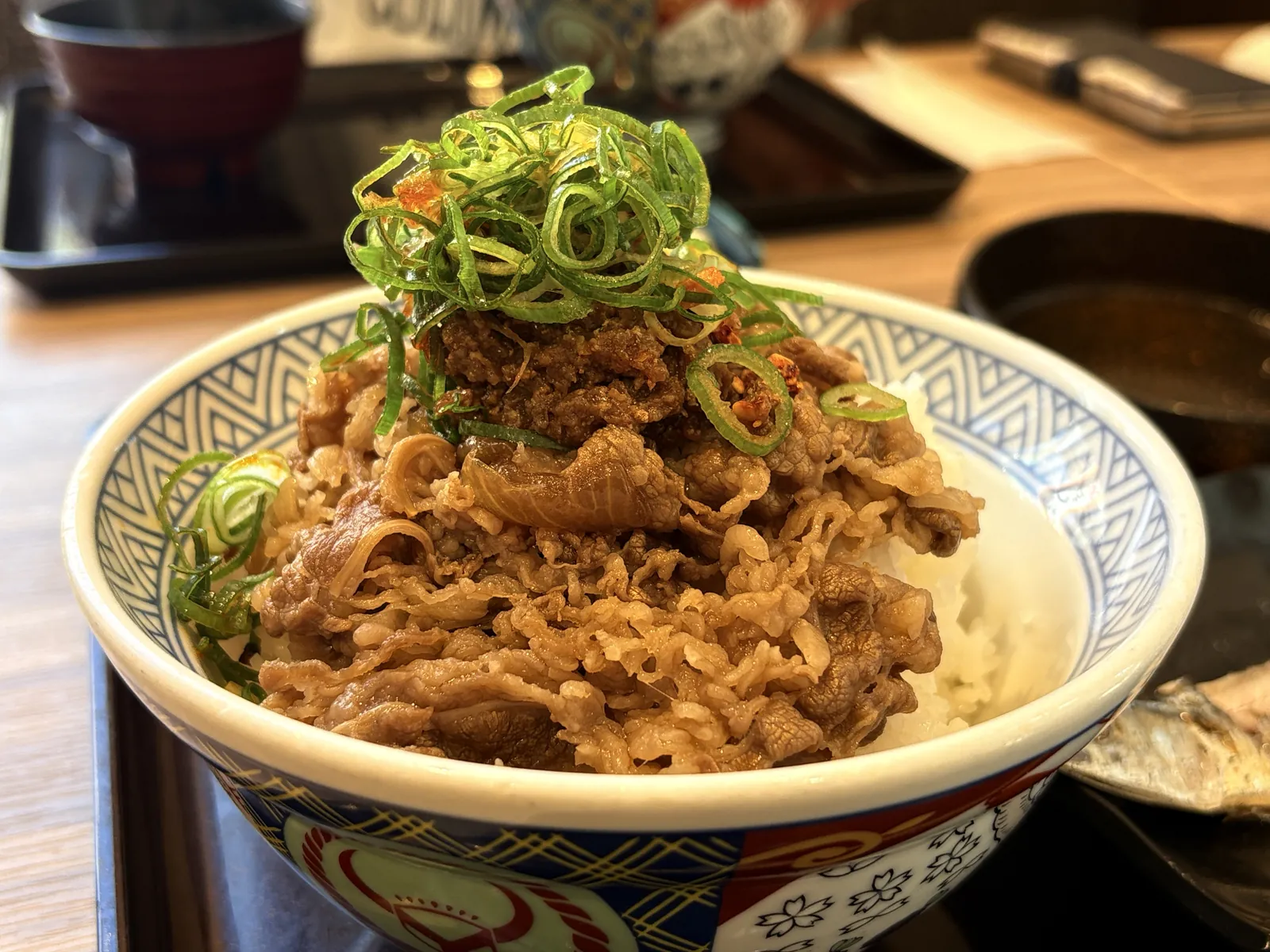 ご飯の上に牛をのせ、ネギと肉味噌をトッピング