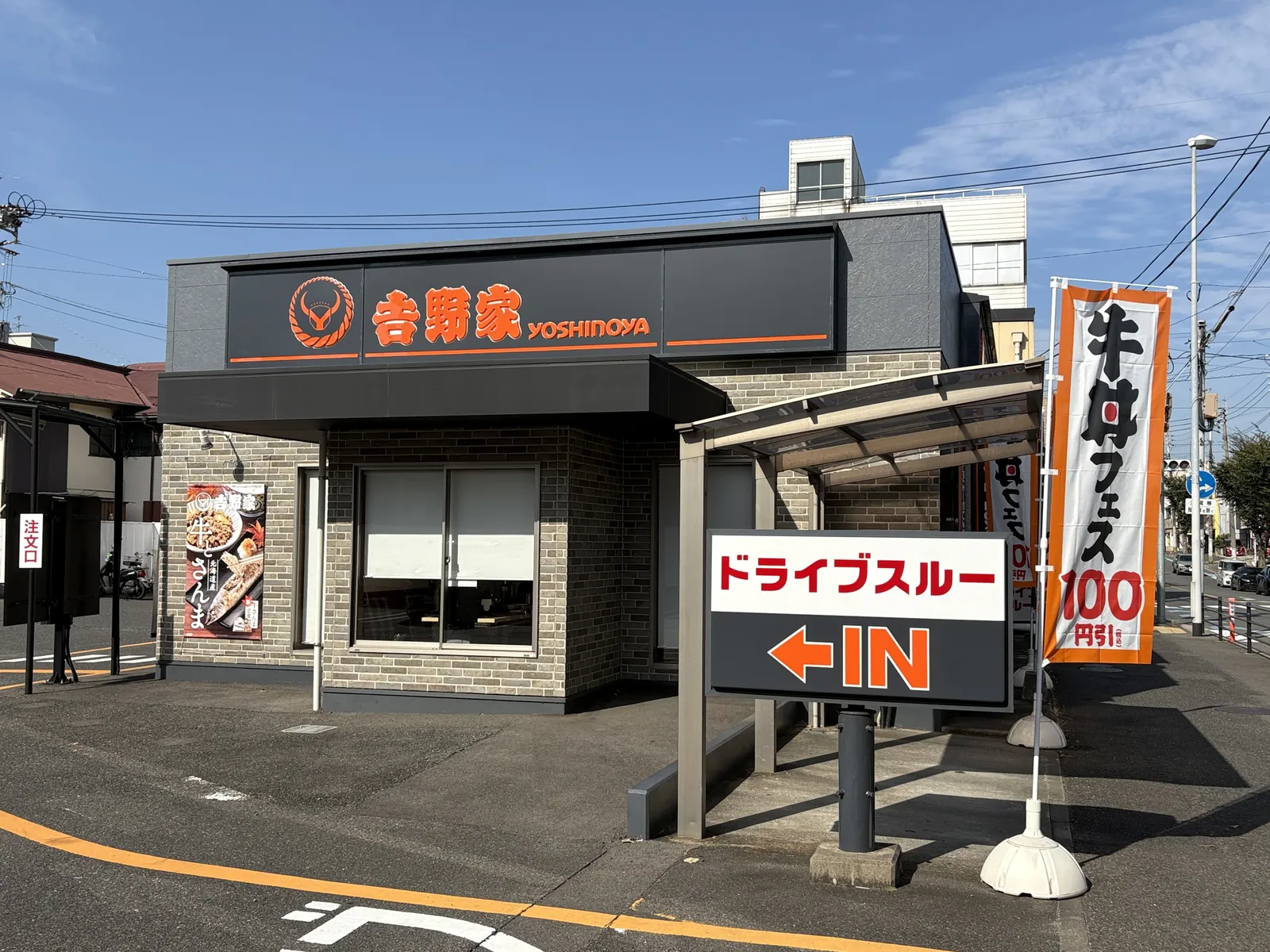店舗入口側の外観。「牛丼フェス」ののぼりとドライブスルーの看板